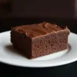 Homemade chocolate cake with rich chocolate frosting on a serving plate